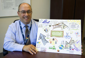 Director holding artwork from a staff member