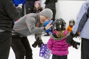 man high-fiving a girl on the ice