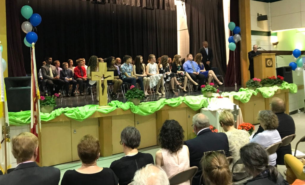 group of students sitting on stage during ceremony