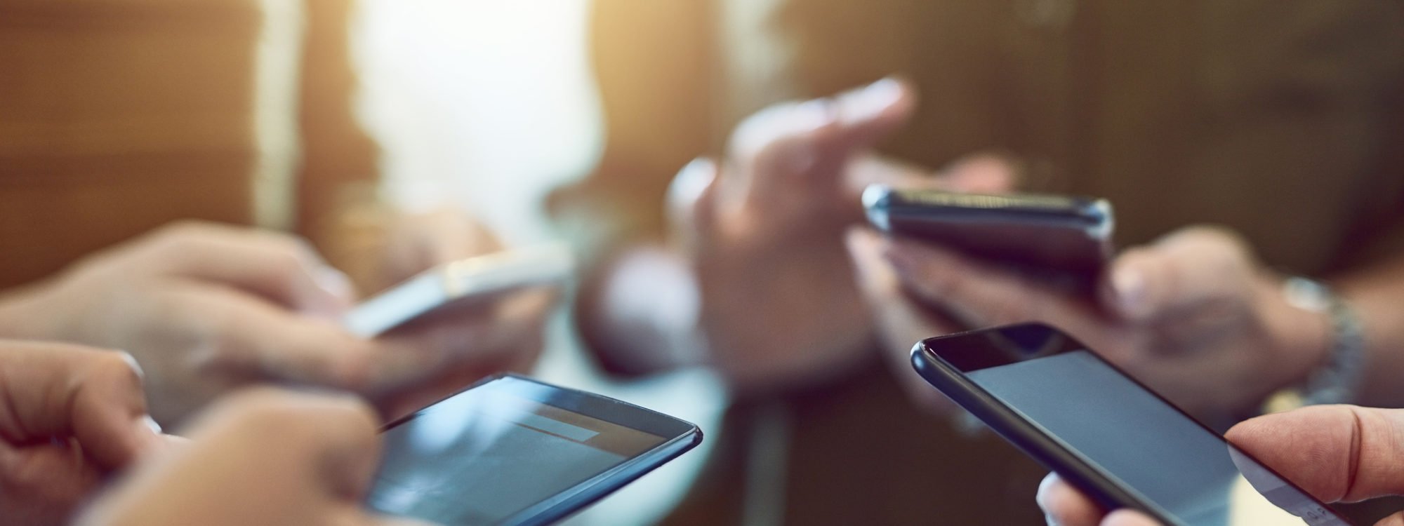 Cropped shot of a group of colleagues using their smart phones in synchronicity