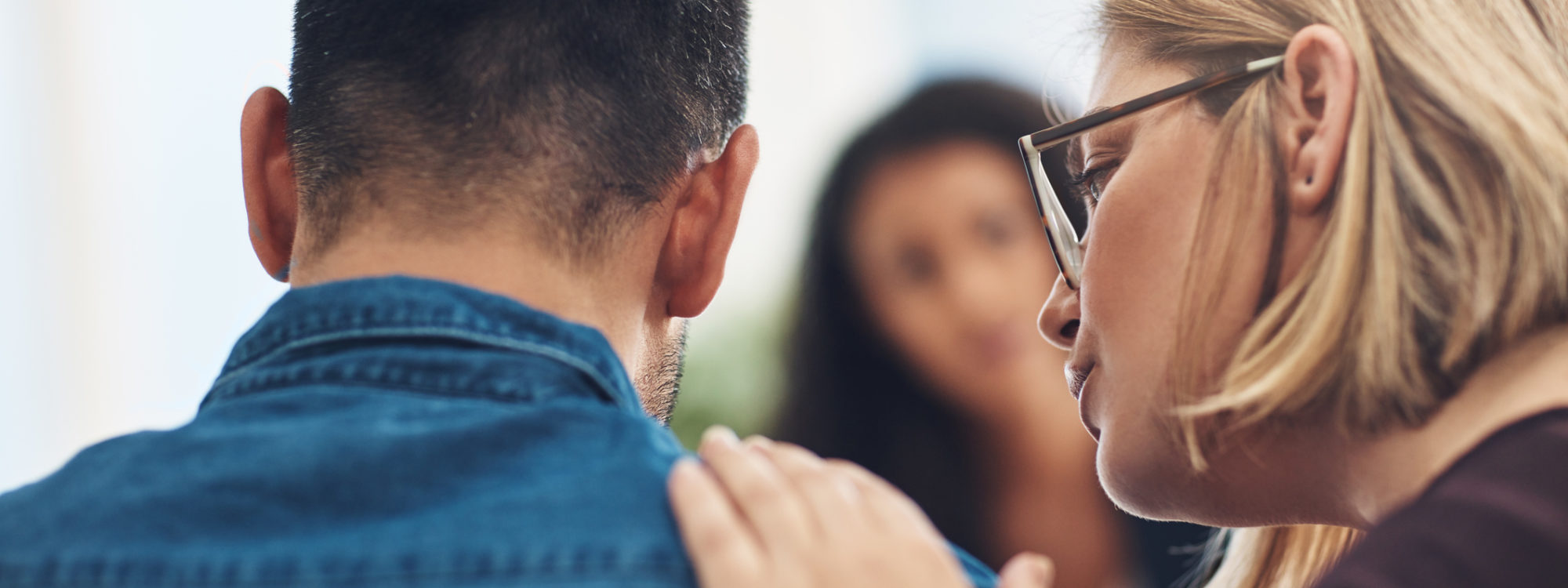 Shot of a wife consoling her husband during a counseling session with a therapist