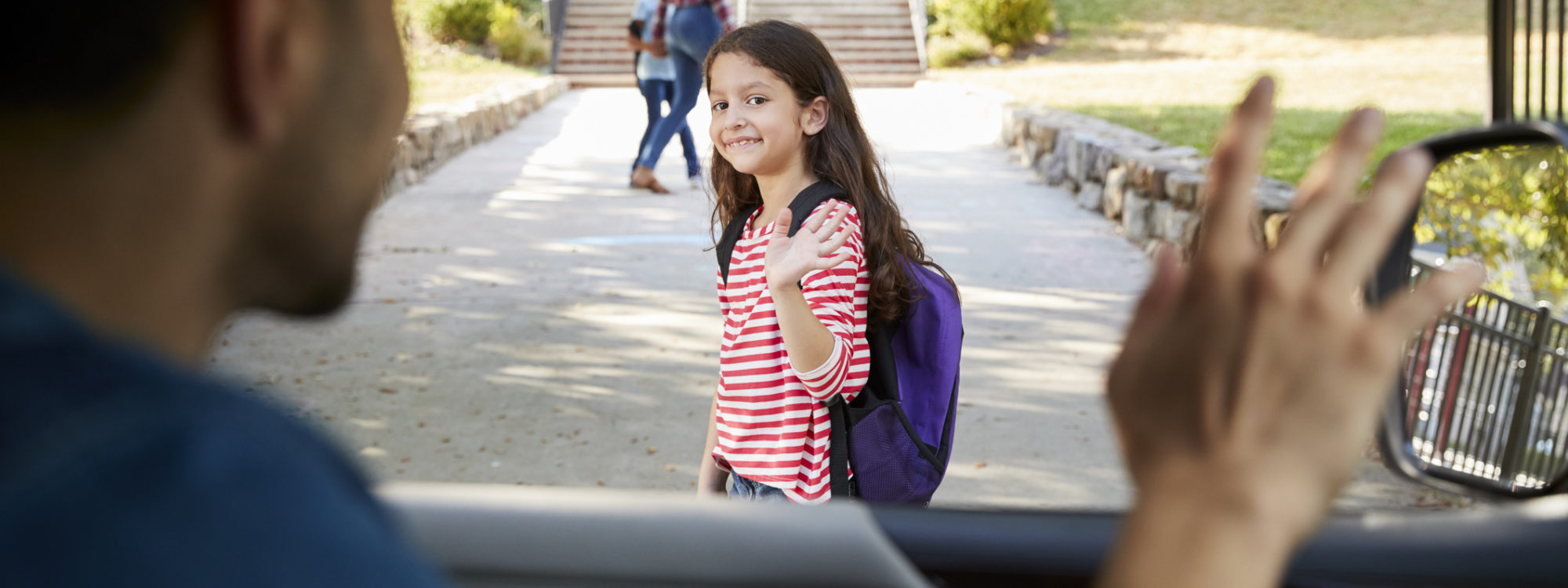 Father In Car Dropping Off Daughter In Front Of School Gates