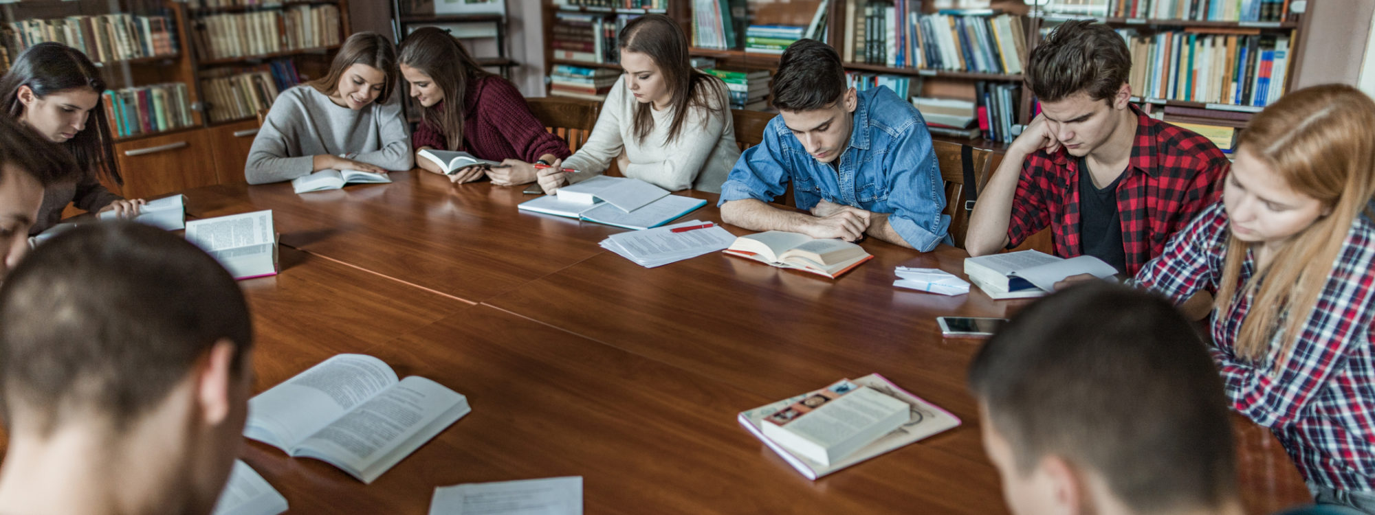 Large group of high school students learning in the library.