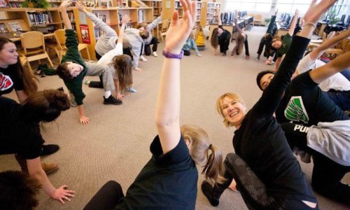 students performing yoga in library