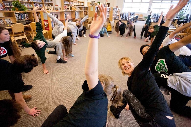students performing yoga in library