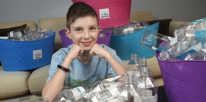 student with plastic water bottles for recycling