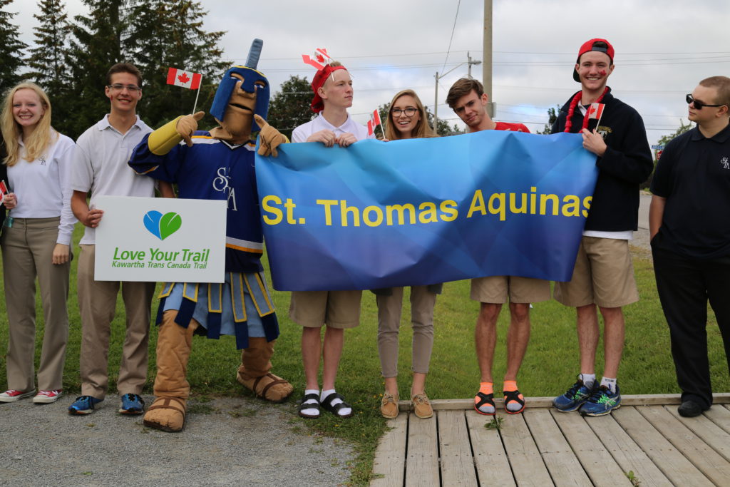 students standing with school mascot