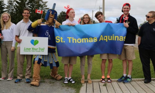 students standing with school mascot