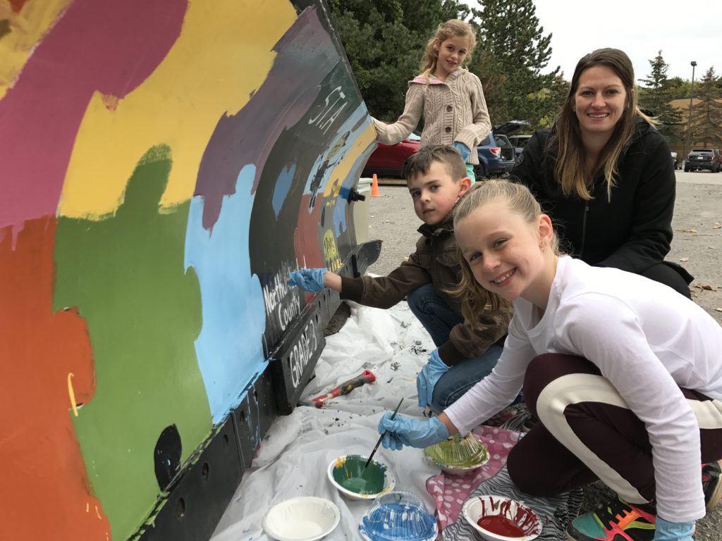 students painting snowplow blade