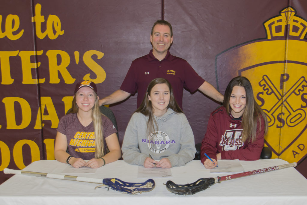 students at table with lacrosse sticks
