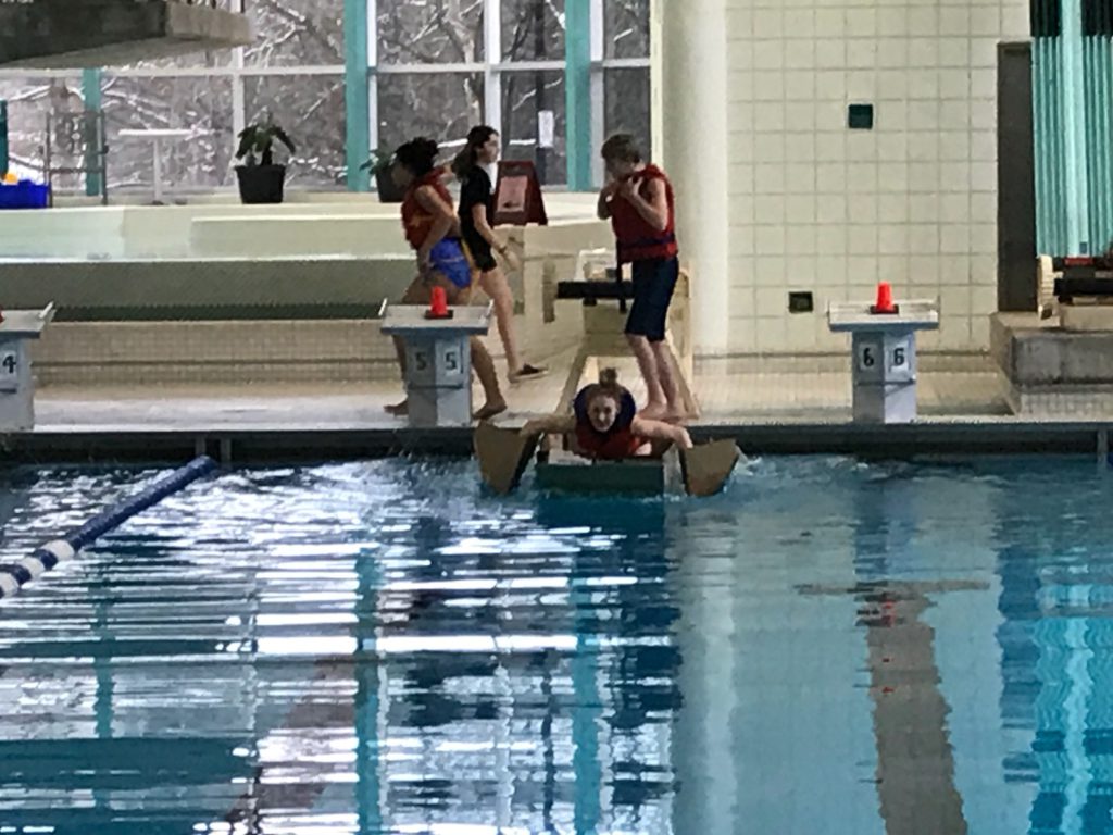 student competing in cardboard boat race