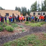 students and staff standing around the school garden
