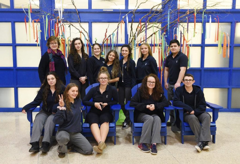 group of students in front of a tree of ribbons