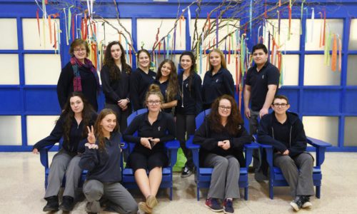group of students in front of a tree of ribbons