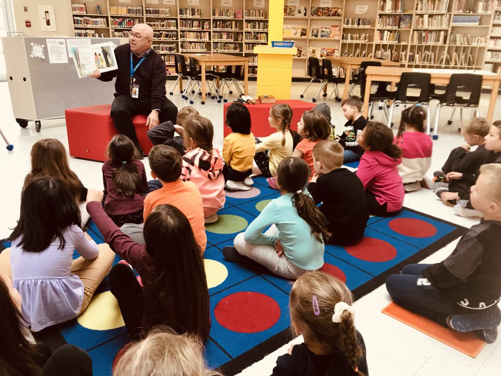 man reading to students