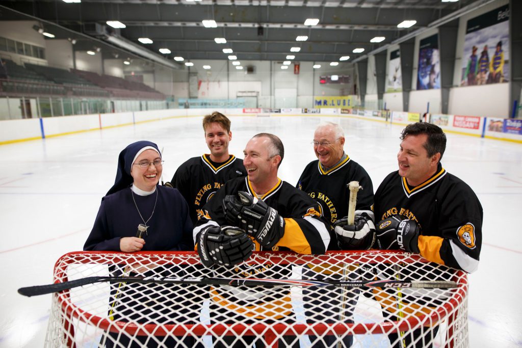 people standing at hockey net