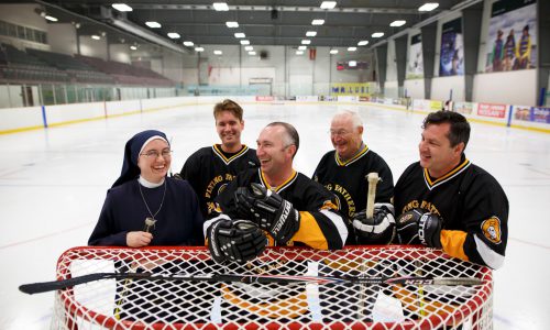 people standing at hockey net