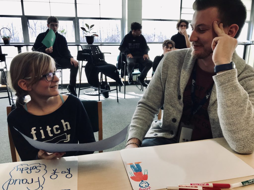 student and teacher sitting at table