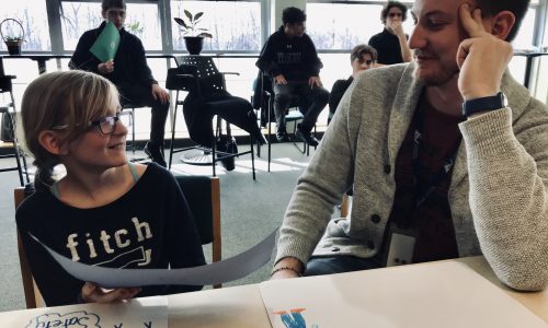 student and teacher sitting at table