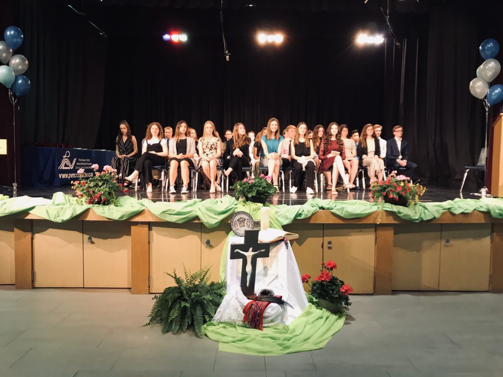 students sitting in chairs on stage