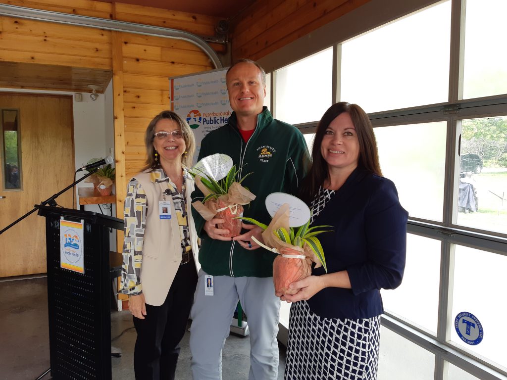 man and woman holding plants