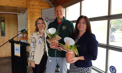 man and woman holding plants