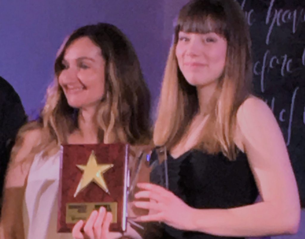 student holding awards