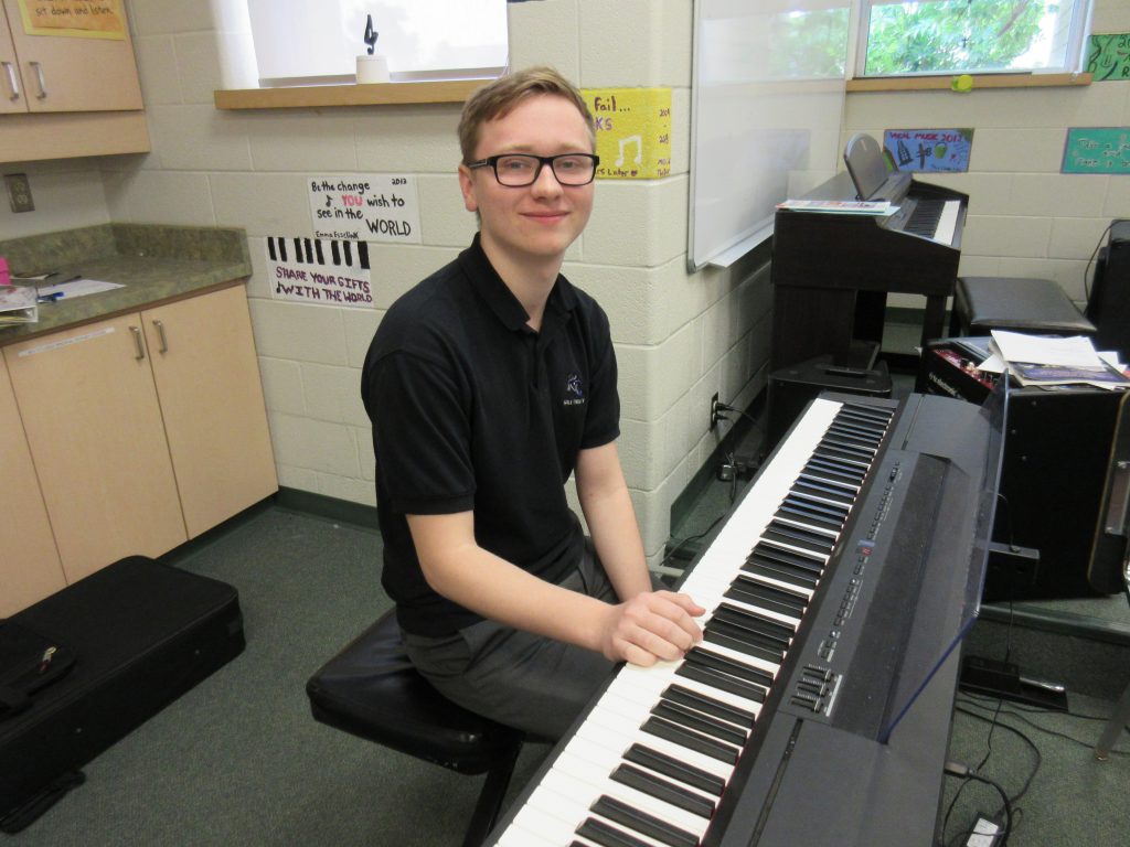 student sitting at piano