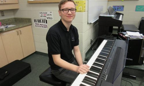 student sitting at piano