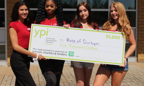 students holding decorative cheque