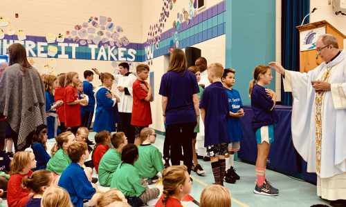 priest blessing students at school mass