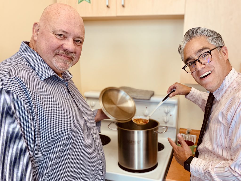 two men serving soup