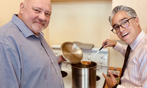 two men serving soup