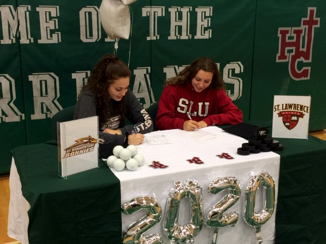 two students sitting at decorated table signing letter