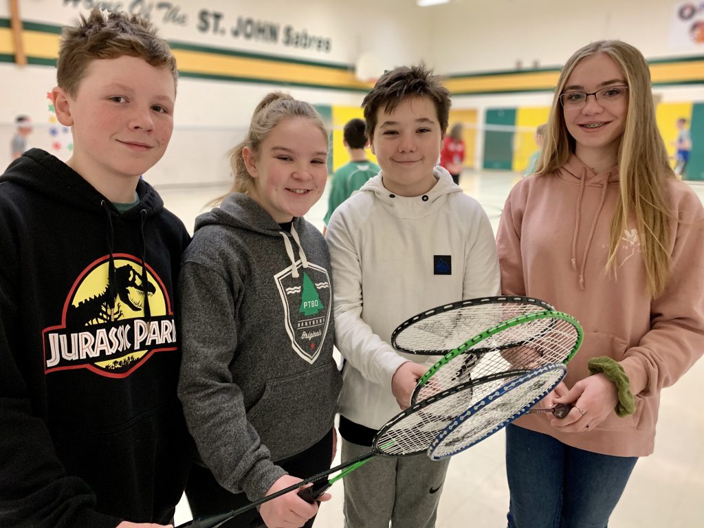 4 students holding badminton rackets