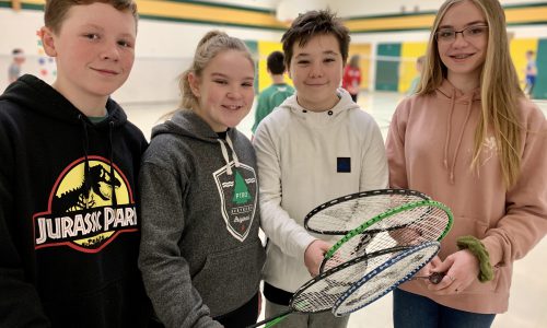 4 students holding badminton rackets