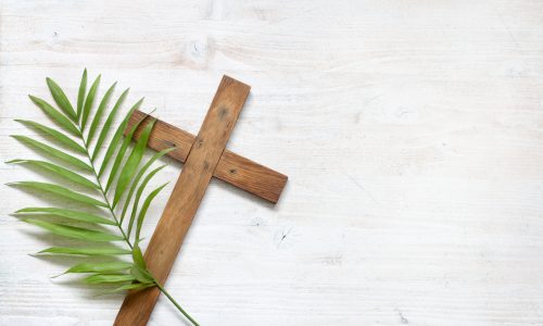 Cross and palm on wooden white background easter sign symbol concept