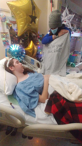 Katie in hospital looking at shirt that reads "You've got this, kid!"