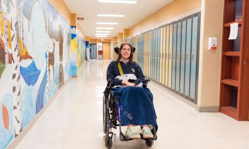 Katie Girard in her wheelchair in St. Stephen hallway.