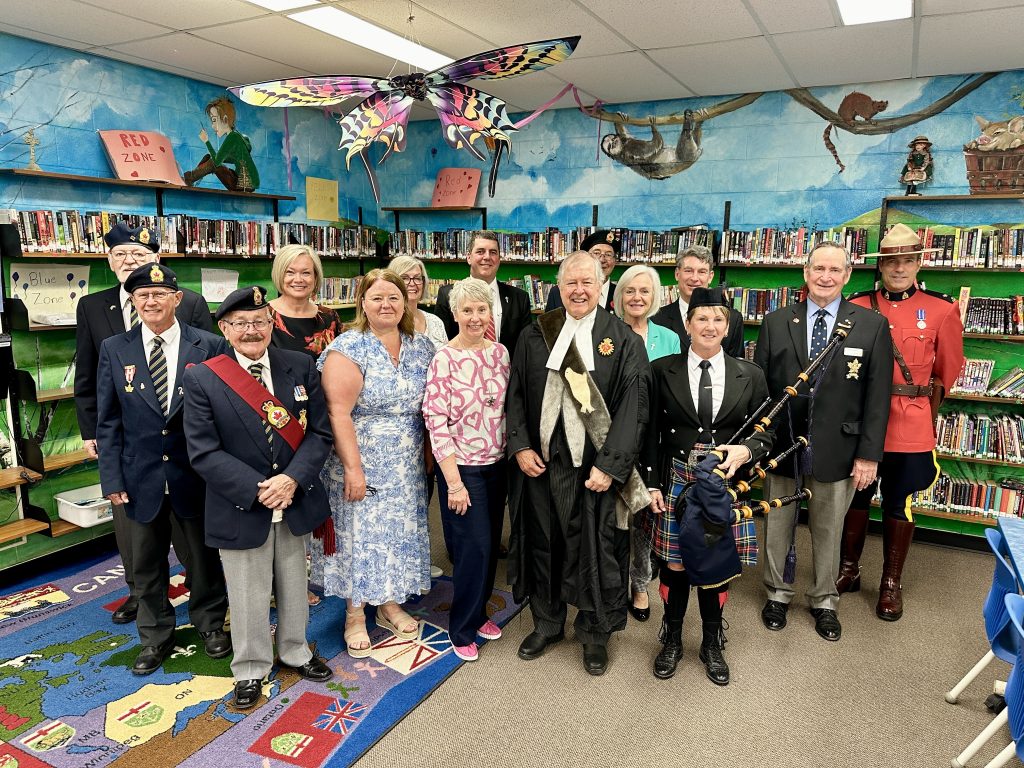 A group of dignitaries gathered in a school library 