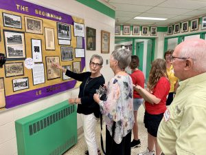 Former grads point out images on a historical display of old school photos. 