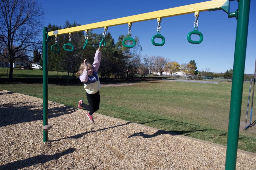 Child playing on new play structure in schoolyard.