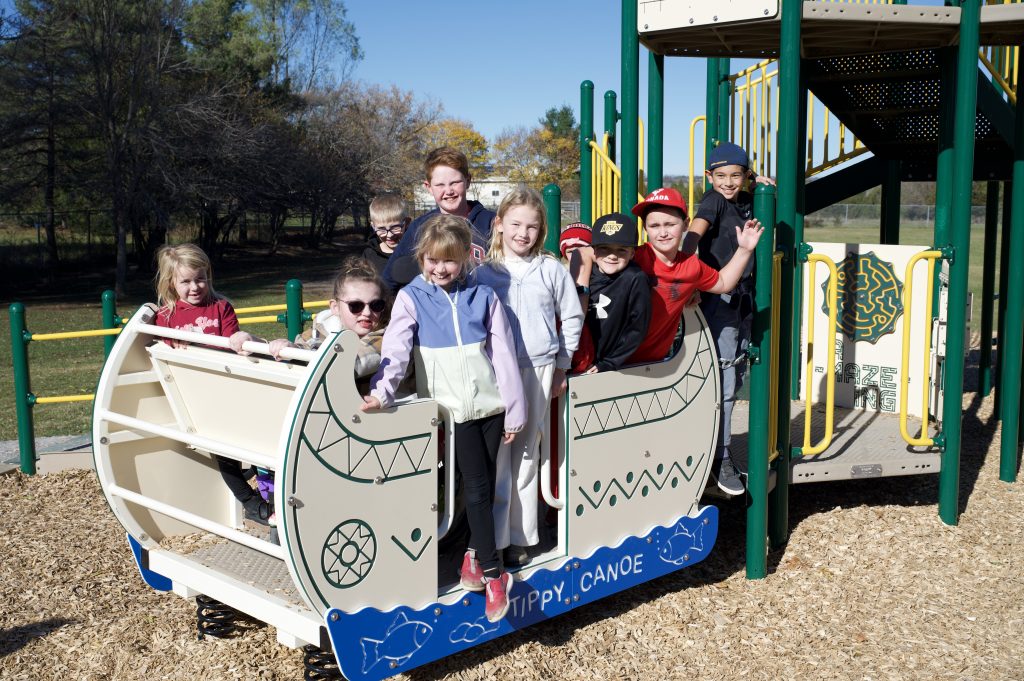 children gathered on play structure in a schoolyard.
