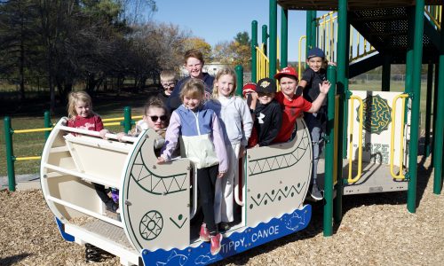 children gathered on play structure in a schoolyard.