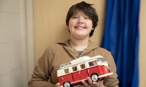 Student posing with bus in his hands.