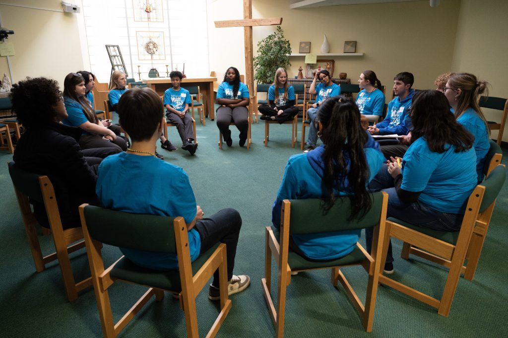 Group of students wearing blue sitting in a circle