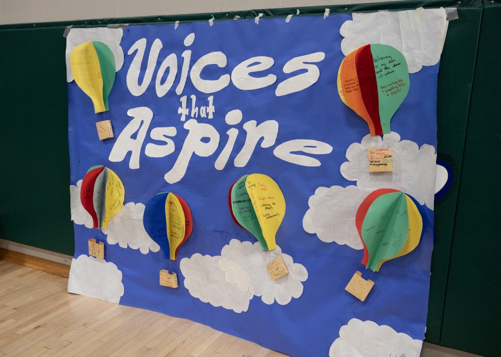 Voices that Aspire banner on a blue background on a wall.