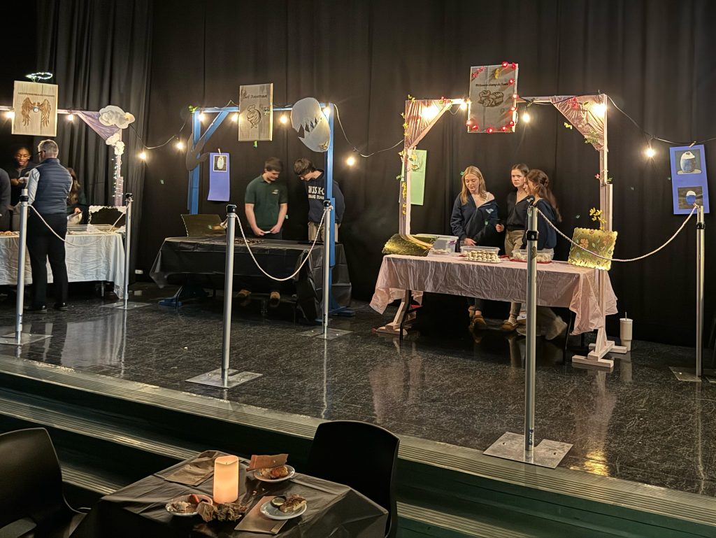 Students with baking stations serving cookies to students and staff