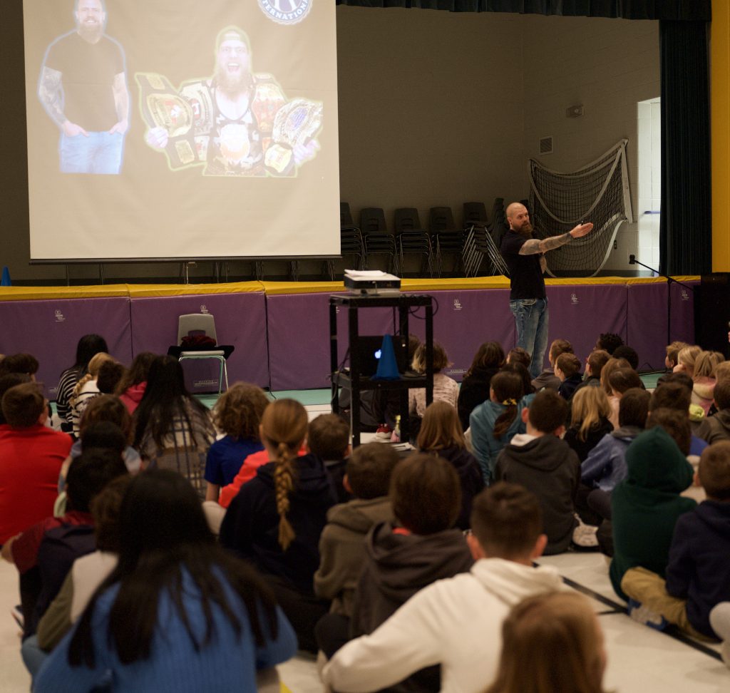 Man gives presentation to a room full of kids.