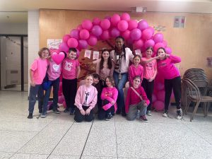Group of students standing in front of a pink display for Pink Shirt Day